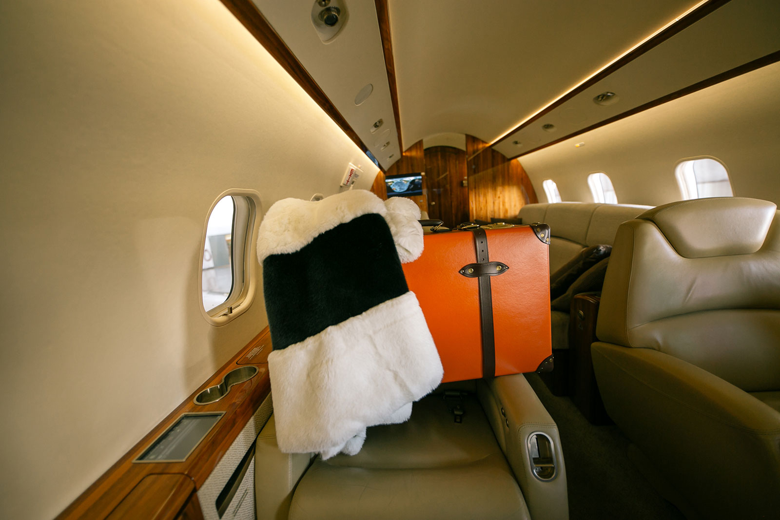 suitcase and fur coat on a plane, secret location concept store travel essentials